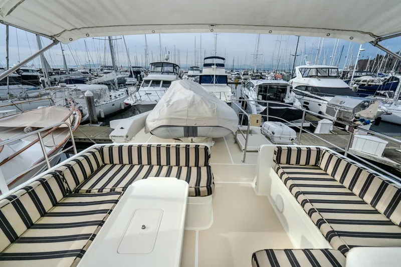 Slide: The Image of 2001 Fleming 55 Pilothouse yacht with striped seating, docked in a marina. - 40