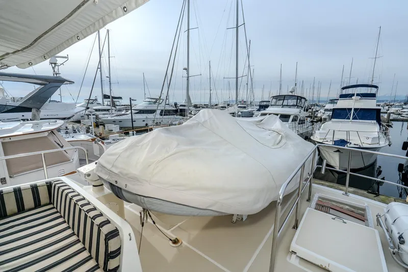 Slide: The Image of 2001 Fleming 55 Pilothouse yacht docked at marina with covered deck and striped seating. - 41