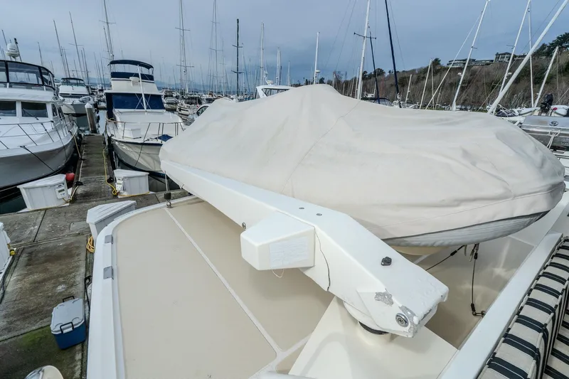 Slide: The Image of 2001 Fleming 55 Pilothouse yacht docked, covered tender on deck, surrounded by other boats. - 42
