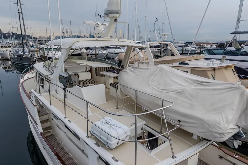Slide: The Image of 2001 Fleming 55 Pilothouse yacht docked at marina, featuring spacious deck and covered seating area. - 45