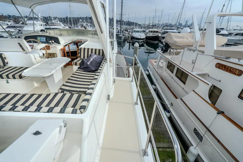 Slide: The Image of 2001 Fleming 55 Pilothouse yacht with striped seating, docked in a marina. - 47