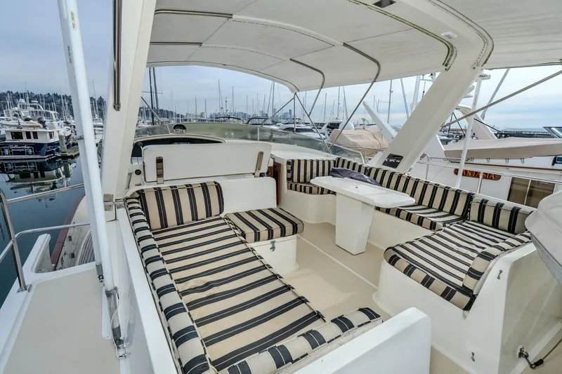 Slide: The Image of 2001 Fleming 55 Pilothouse yacht with striped seating in marina setting. - 49