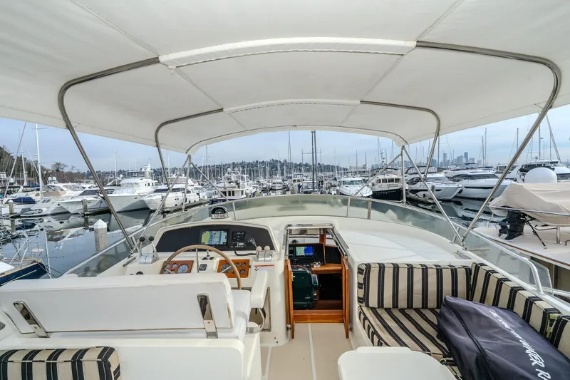 Slide: The Image of 2001 Fleming 55 Pilothouse yacht interior with marina view, featuring helm and seating area. - 50