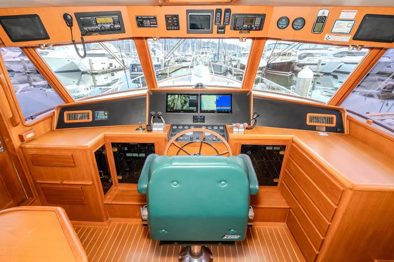 Slide: The Image of Pilothouse interior of 2001 Fleming 55, featuring navigation equipment and green captain's chair. - 52