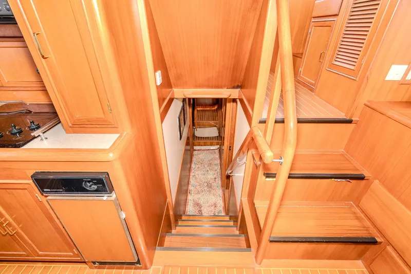 Slide: The Image of Interior of 2001 Fleming 55 Pilothouse yacht with wooden stairs and cabinetry. - 54