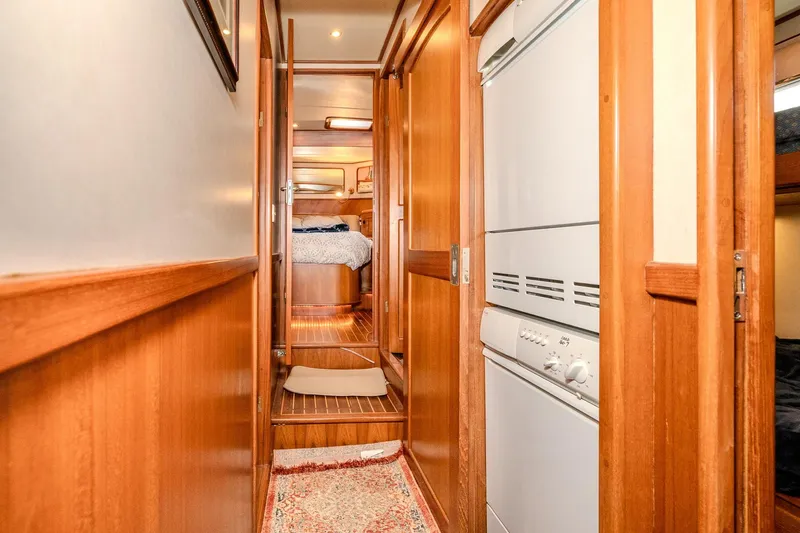 Slide: The Image of Interior hallway of 2001 Fleming 55 Pilothouse yacht with wood paneling and laundry appliances. - 55