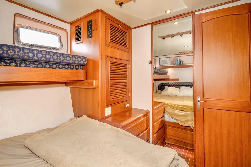 Slide: The Image of Interior cabin of 2001 Fleming 55 Pilothouse yacht with wooden furnishings and cozy bedding. - 60