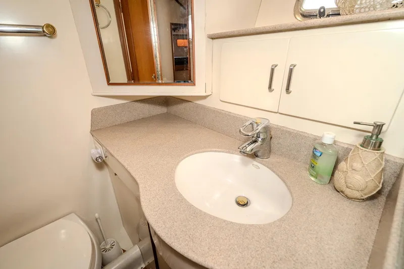Slide: The Image of Bathroom sink area in a 2001 Fleming 55 Pilothouse yacht, featuring countertop and mirror. - 63