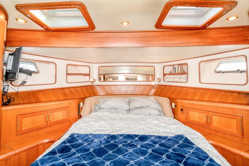 Slide: The Image of Luxurious 2001 Fleming 55 Pilothouse yacht bedroom with wood accents and skylights. - 65