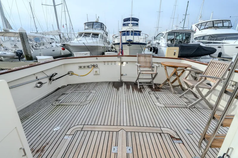 Slide: The Image of Spacious deck of a 2001 Fleming 55 Pilothouse yacht, featuring wooden chairs and table. - 7