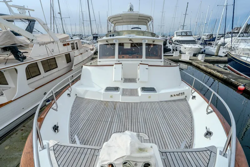 Slide: The Image of 2001 Fleming 55 Pilothouse yacht docked at marina, showcasing spacious deck and elegant design. - 75