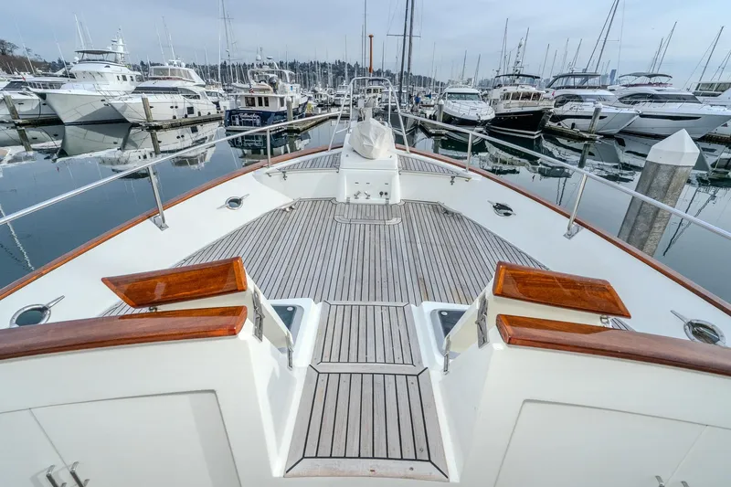 Slide: The Image of 2001 Fleming 55 Pilothouse yacht docked in a marina, surrounded by other boats. - 78