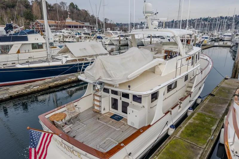 Slide: The Image of 2001 Fleming 55 Pilothouse yacht docked at marina, featuring spacious deck and covered seating area. - 8