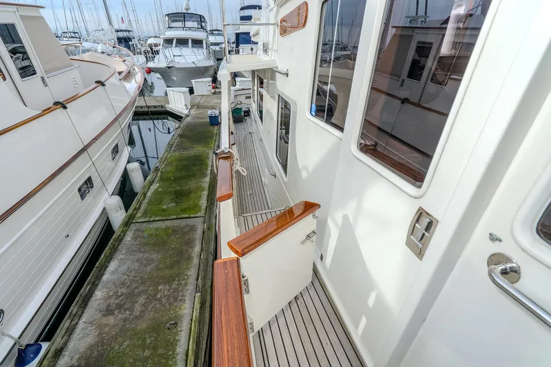 Slide: The Image of 2001 Fleming 55 Pilothouse yacht docked at marina, showcasing side deck and railing. - 81
