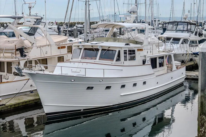 Slide: The Image of 2001 Fleming 55 Pilothouse yacht docked in a marina, surrounded by other boats. - 82