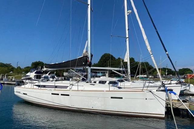 The Image of 2014 Jeanneau Sun Odyssey 439 sailboat docked in a marina under clear blue skies. - 0
