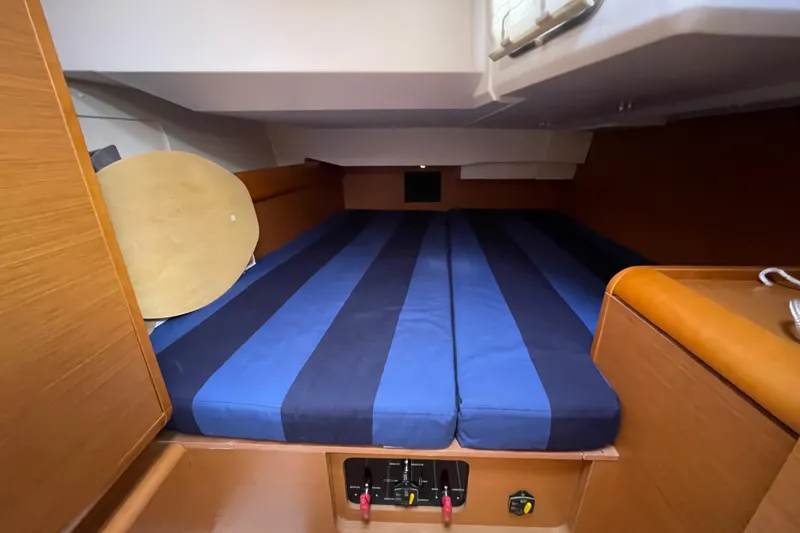 Slide: The Image of Cozy cabin interior of 2014 Jeanneau Sun Odyssey 439 sailboat with striped bedding. - 25