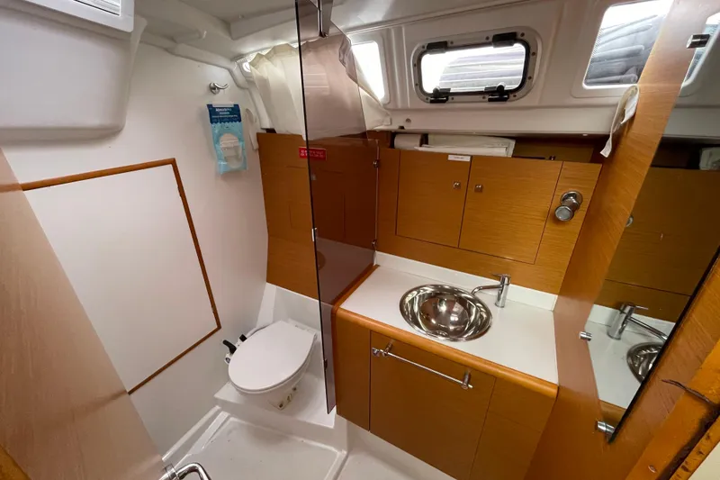 Slide: The Image of 2014 Jeanneau Sun Odyssey 439 bathroom with wooden cabinets, sink, and toilet. - 28