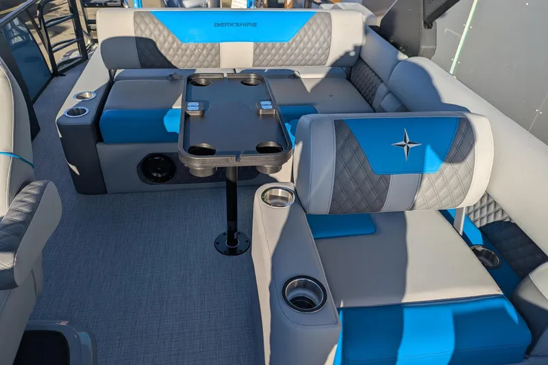 Slide: The Image of 2026 Berkshire 23SB2 STS boat interior with blue and gray seating and cup holders. - 12