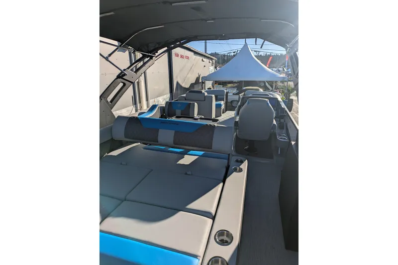 Slide: The Image of 2026 Berkshire 23SB2 STS boat interior with seating and canopy, displayed outdoors. - 8