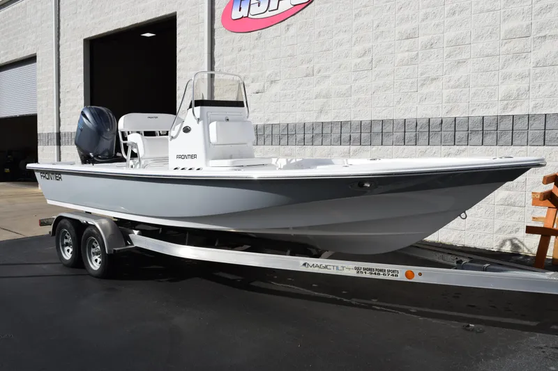 Slide: The Image of 2026 Frontier 2104 boat on trailer outside a building. - 2