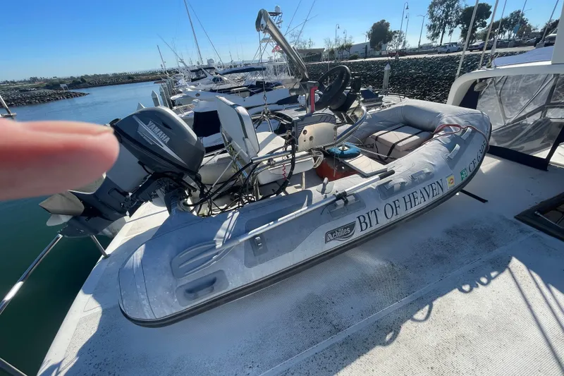 Slide: The Image of Inflatable boat "Bit of Heaven" on 1990 Spindrift Cockpit Motoryacht deck, marina background. - 13