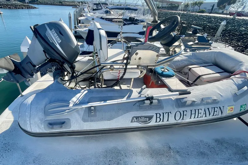Slide: The Image of Inflatable boat "Bit of Heaven" with Yamaha motor, docked near Spindrift Cockpit Motoryacht, 1990 model. - 14