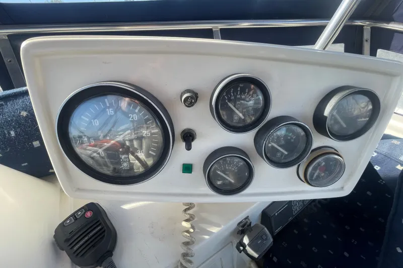 Slide: The Image of Control panel of a 1990 Spindrift Cockpit Motoryacht with gauges and radio handset. - 24