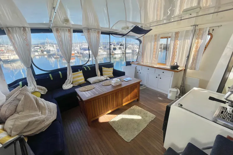 Slide: The Image of Luxurious 1990 Spindrift Cockpit Motoryacht interior with cozy seating and scenic marina view. - 25