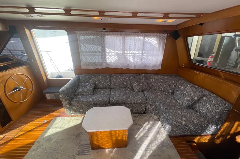 Slide: The Image of 1990 Spindrift Cockpit Motoryacht interior with patterned sofa and wooden accents. - 37