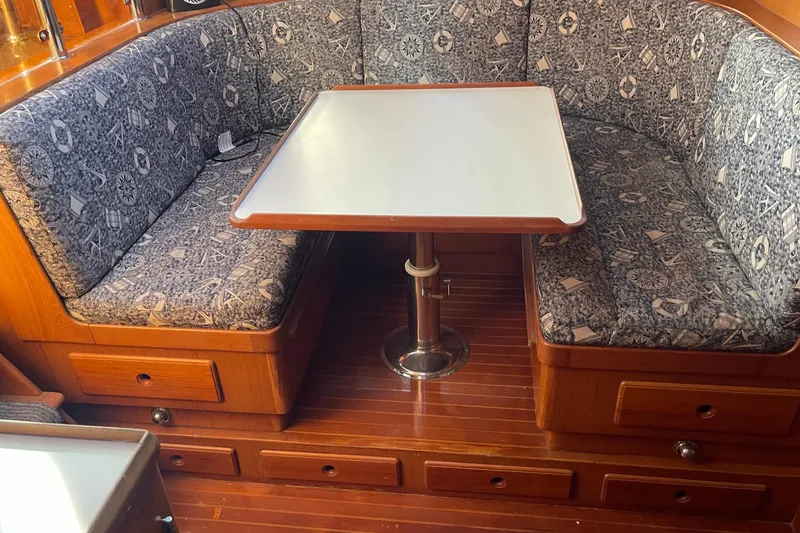 Slide: The Image of 1990 Spindrift COCKPIT MOTORYACHT interior with patterned seating and wooden table. - 46