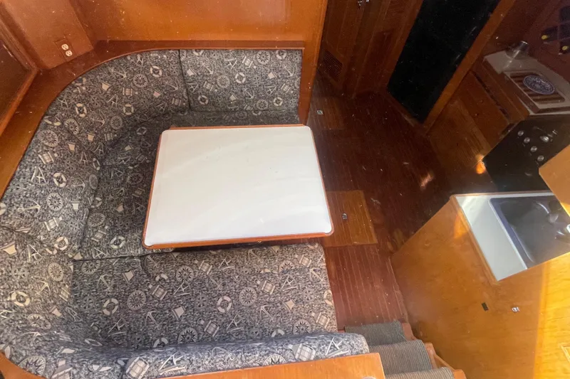 Slide: The Image of 1990 Spindrift COCKPIT MOTORYACHT interior with patterned seating and compact kitchen area. - 48