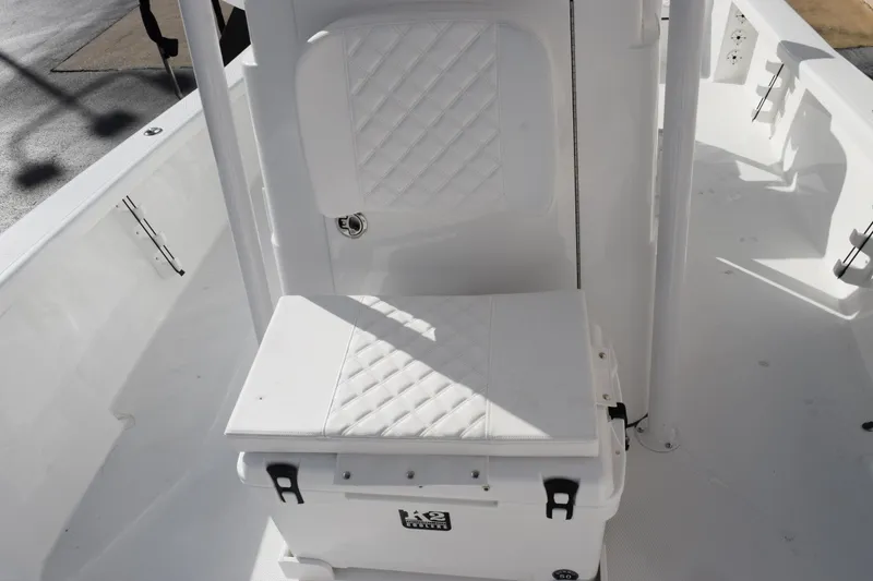 Slide: The Image of 2026 BlackJack 256 Bay boat interior with white cushioned seating and cooler. - 13