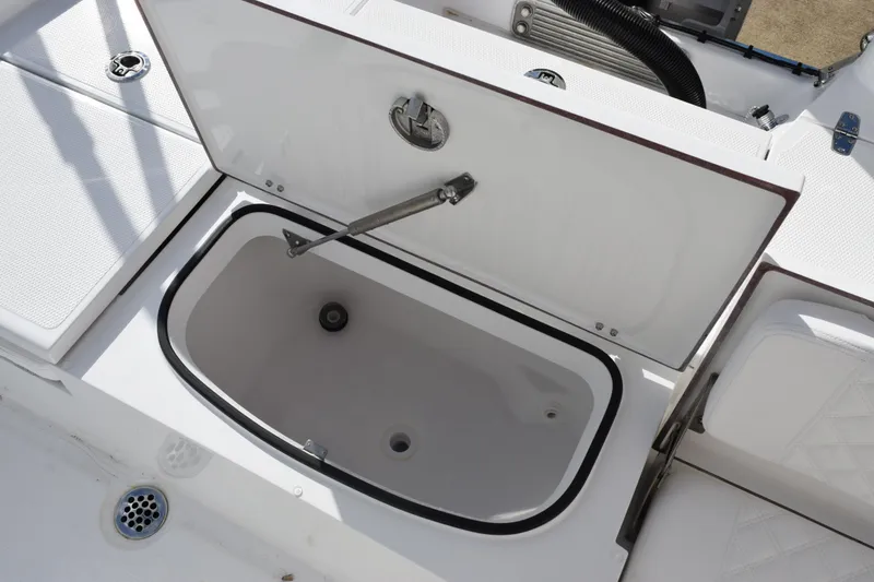 Slide: The Image of Open storage compartment on 2026 BlackJack 256 Bay boat deck. - 19