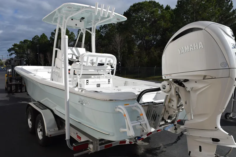 Slide: The Image of 2026 BlackJack 256 Bay boat with Yamaha engine on a trailer, parked outdoors. - 6
