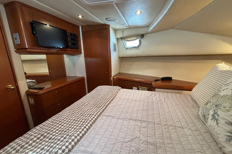 Slide: The Image of Luxurious 1996 Queenship yacht bedroom with TV, wood cabinetry, and cozy bedding. - 14