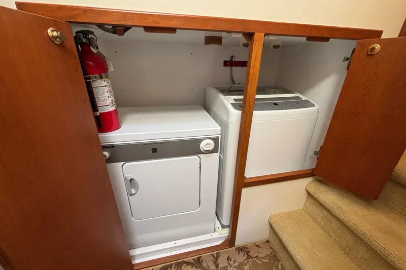 Slide: The Image of Laundry area on a 1996 Queenship yacht with washer, dryer, and fire extinguisher. - 23