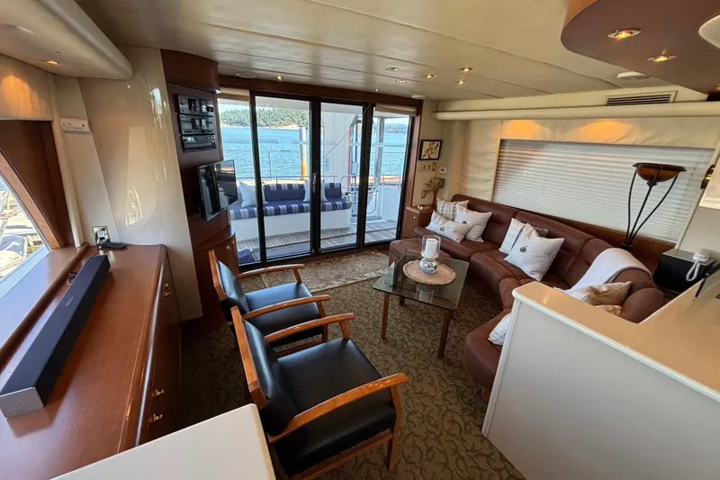 Slide: The Image of Luxurious 1996 Queenship yacht interior with elegant seating, glass table, and scenic ocean view. - 27