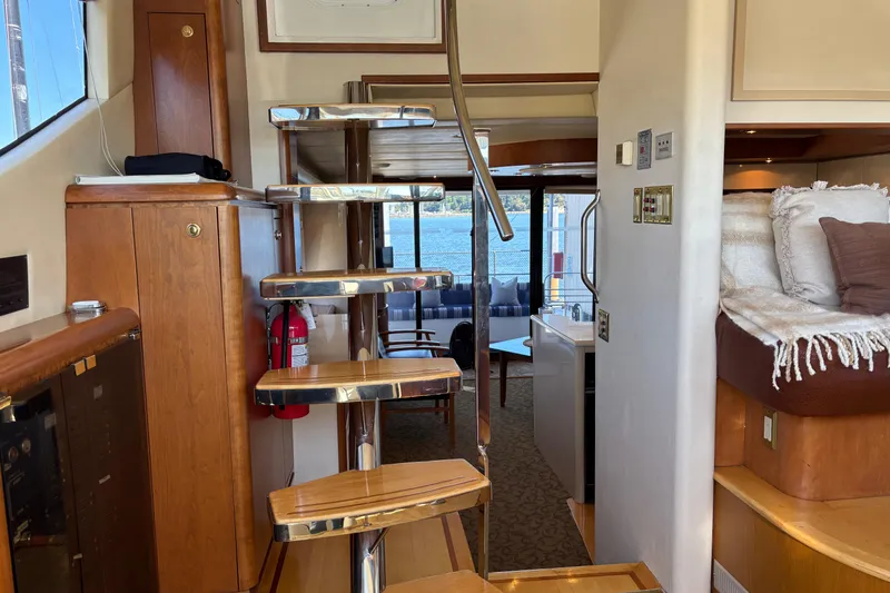 Slide: The Image of Interior of a 1996 Queenship yacht with wooden stairs and cozy seating area. - 29