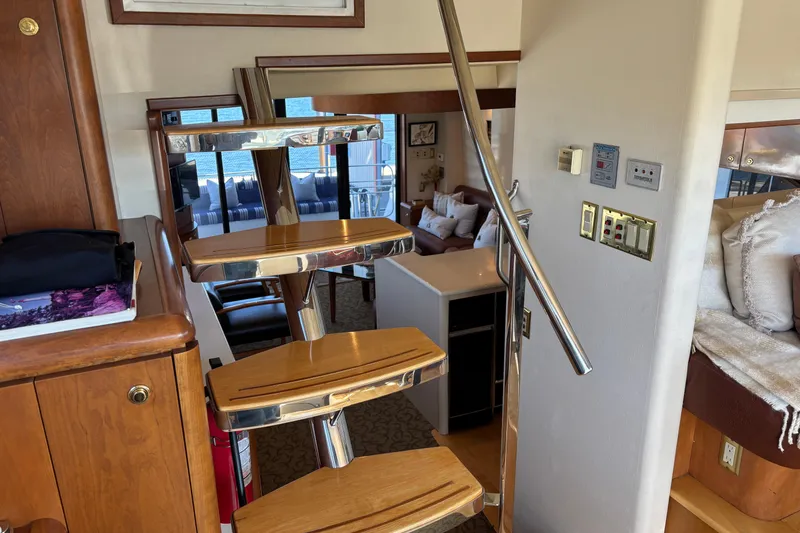 Slide: The Image of Interior of a 1996 Queenship yacht featuring a modern staircase and cozy living area. - 31