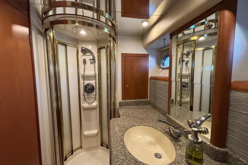 Slide: The Image of Luxurious 1996 Queenship yacht bathroom with shower, sink, and elegant wood accents. - 4