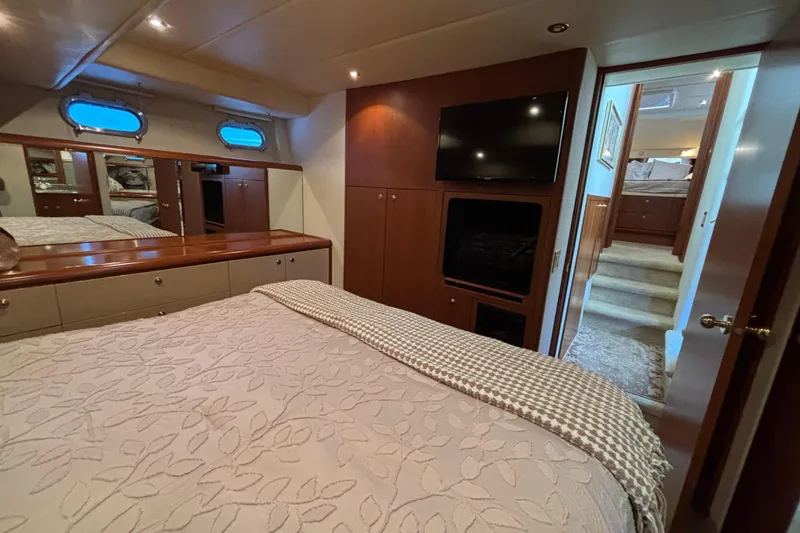 Slide: The Image of Luxurious 1996 Queenship yacht bedroom with TV, elegant decor, and cozy bedding. - 6