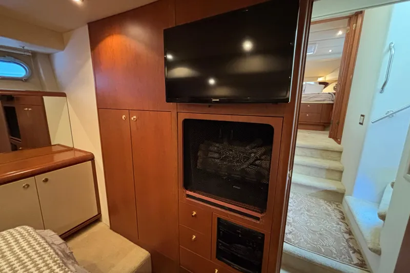 Slide: The Image of Luxurious 1996 Queenship yacht interior with TV, fireplace, and elegant wood cabinetry. - 8