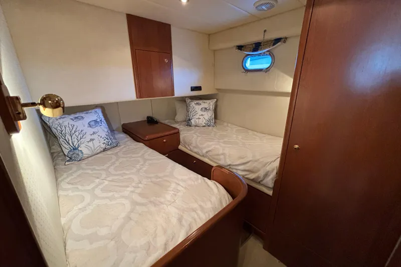 Slide: The Image of Cozy twin cabin on 1996 Queenship yacht with nautical-themed decor. - 9
