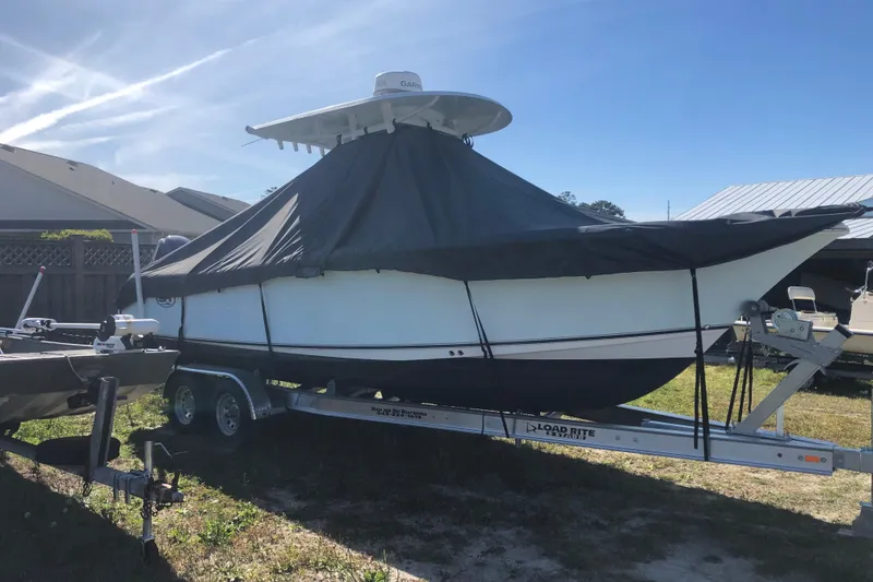 Slide: The Image of 2015 Sea Hunt Gamefish 25 boat covered on trailer, parked outdoors. - 11