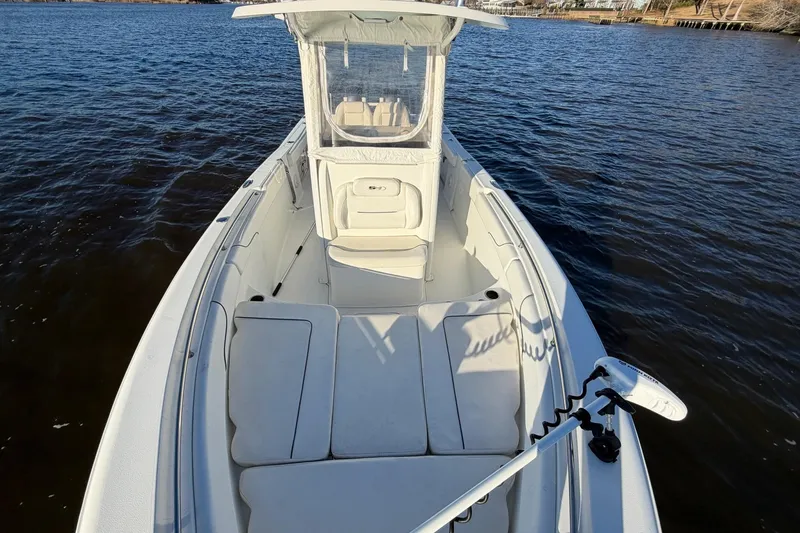 Slide: The Image of 2015 Sea Hunt Gamefish 25 boat on calm water, featuring spacious deck and seating. - 5