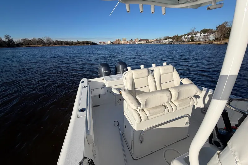 Slide: The Image of 2015 Sea Hunt Gamefish 25 boat on calm water with dual engines and white seating. - 8
