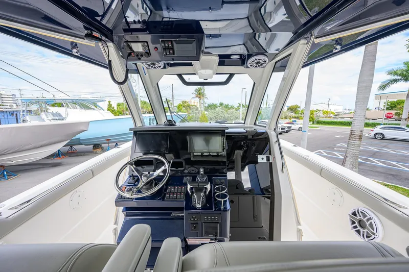 Slide: The Image of 2023 Pursuit S 328 Sport boat cockpit with modern controls and steering wheel. - 10