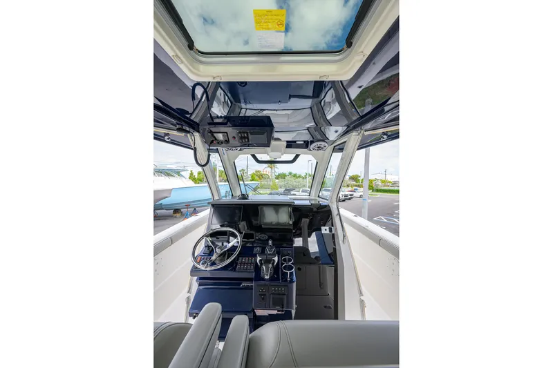 Slide: The Image of 2023 Pursuit S 328 Sport boat cockpit with modern controls and steering wheel. - 11