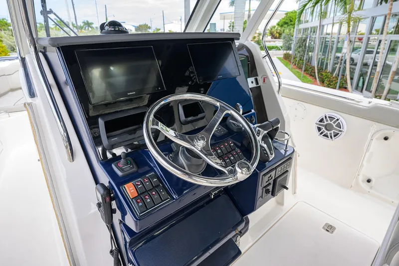 Slide: The Image of 2023 Pursuit S 328 Sport boat helm with modern controls and dual displays. - 15